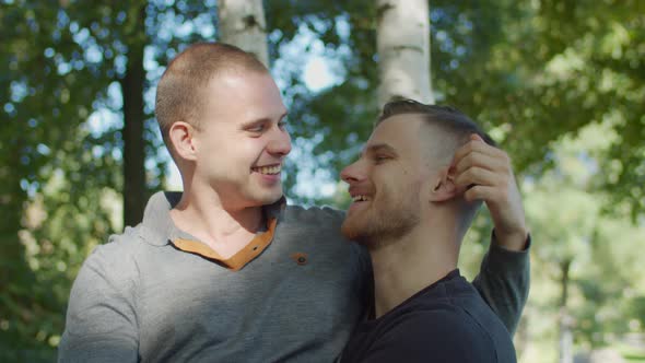 Happy Gay Couple Outdoors Hugging and Smiling