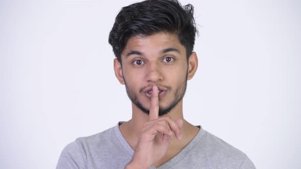 Young Happy Bearded Indian Man with Finger on Lips