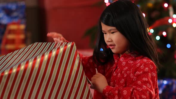 Young girl tearing paper off Christmas present alt