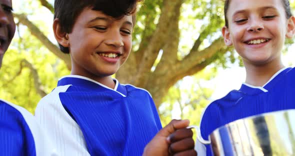 Kids holding winner trophy in park alt