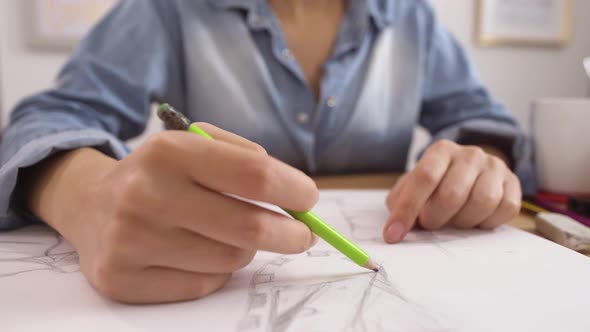 Artist's Hand Doing Sketch with Pencil on Drawing Pad Closeup