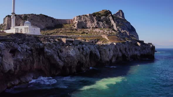 Waves Crashing Into Rocky Foreshore Of Europa Point With Ibrahim-al-Ibrahim Mosque In Gibraltar. Aer