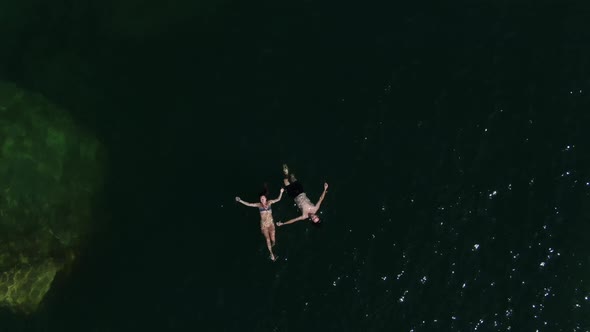 Instagram style drone shot showing a couple in love floating in Lake Havasu in the water during summ