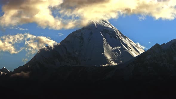 Timelapse of the Onset of Night on a Snowy Peak Glitter of Ice at Sunset Clouds Swirl Over the Top