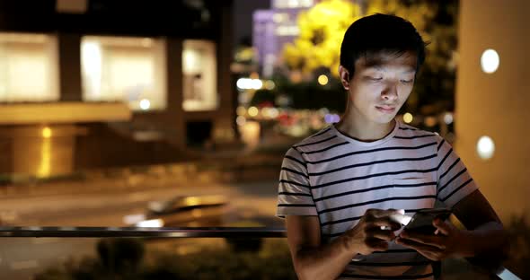 Man using mobile phone in city at night 