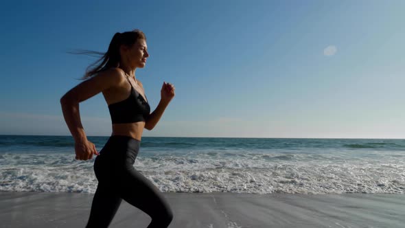 Athletic woman jogging along the beach