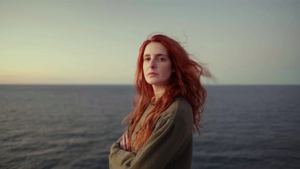 Redheaded woman on viewpoint at sunrise, Ibiza