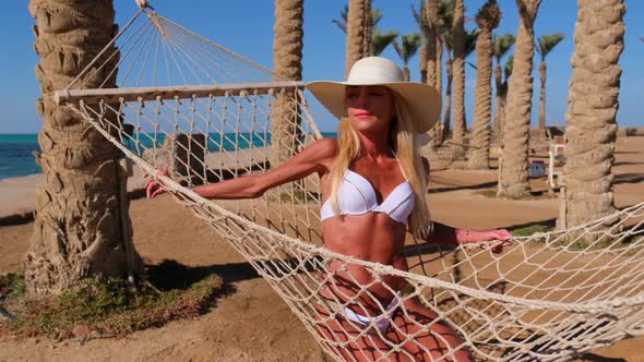 Travel and Vacation Concept  Woman Relaxing on Hammock on the Beach
