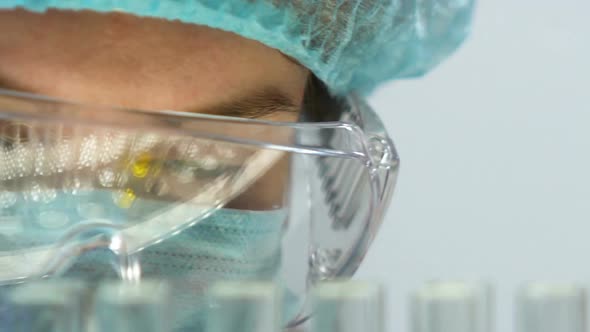 Lab Assistant Checking Experiment Results, Test Tubes Reflecting in Glasses