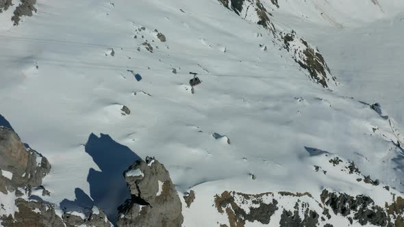 Aerial of gondola going down cable in a snow covered landscape