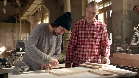 Footage in Slowmotion of Two Young Male Carpenters Dimensioning Wooden Workpieces in Joinery