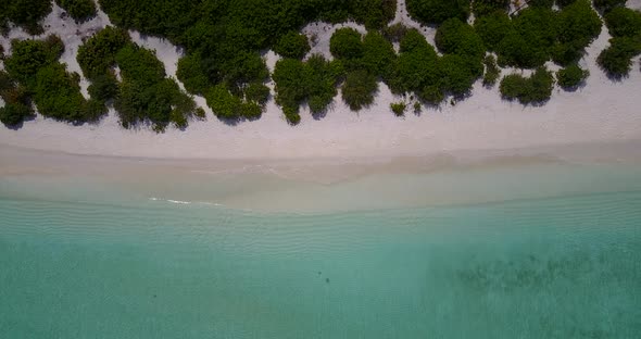 Tropical fly over copy space shot of a white paradise beach and blue sea background in hi res 4K