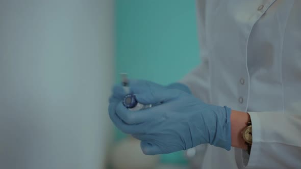 a Nurse Draws a Vaccine Into a Syringe for an Injection