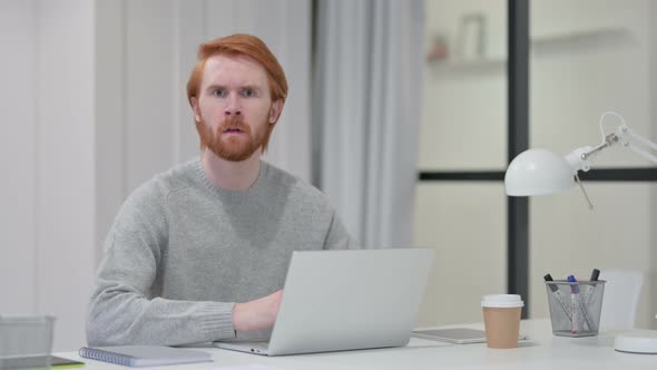 Redhead Man Feeling Shocked While Using Laptop 