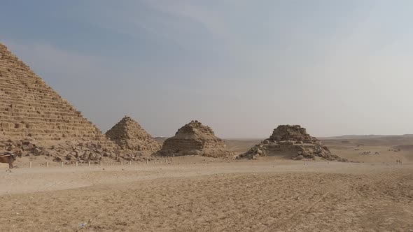 Horse carriage moving towards three satellite pyramids on the north side of the Great Pyramid of Giz