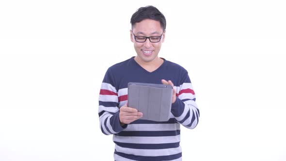 Happy Japanese Hipster Man Talking While Using Digital Tablet