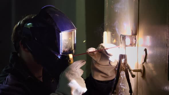 The Welder Man Working in a Factory and Sparks Flying