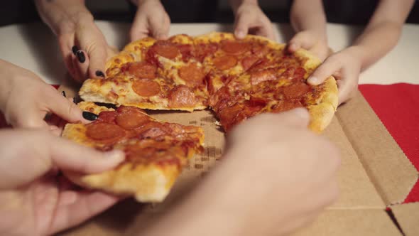 Human Hands Taking Slices of Hot Tasty Italian Pizza From Open Box Food Delivery Service at Party