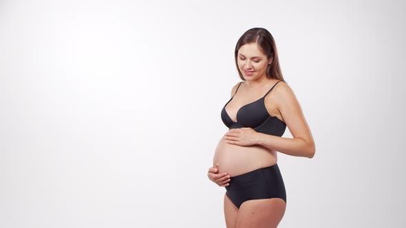 Young, happy and healthy pregnant woman in front of white background.