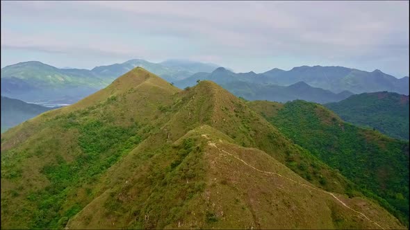 Drone Flies Slowly Over High Brown Peaks of Mountain Ridge