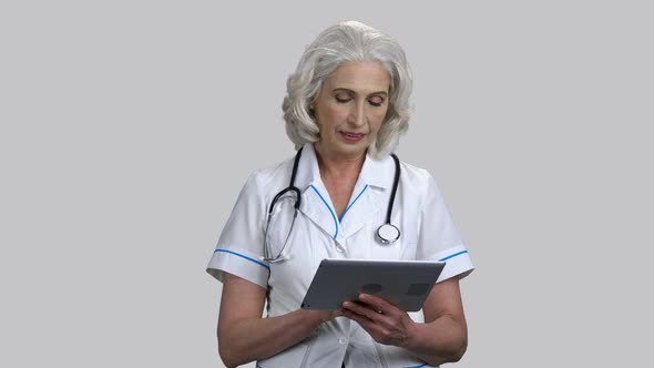 Old Female Doctor Swiping Tablet Pc Screen