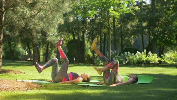 Sporty Fitness Females Doing Bicycle Crunch in Park