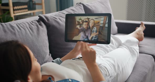 Young Lady Chatting with Friends Online Making Video Call with Tablet at Home