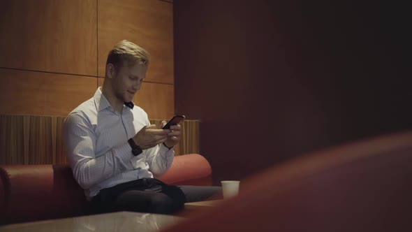 Smiling Businessman checking phone