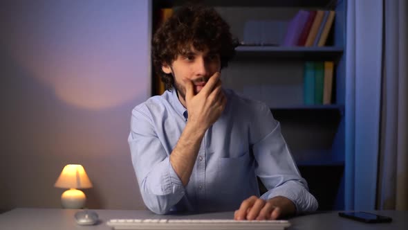 POV Shot of Thoughtful Man Looking Away and Starts Typing on Wireless Keyboard While Sitting at Desk