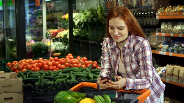 Woman Browsing Her Shopping List on Her Smartphone