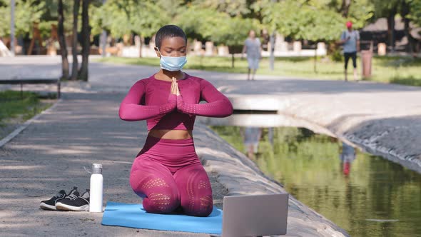Black African Female American Instructor Holding Online Lessons Practicing Yoga Meditating on Mat