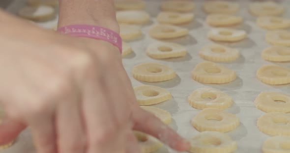 Baker preparing butter cookies with strawberry jam and powdered sugar