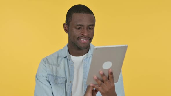 Young African Man Using Digital Tablet Yellow Background