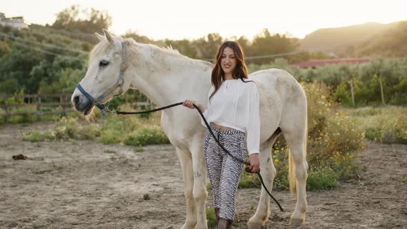 Woman with White Dress and Horse By Her Side Smiles in Countryside Nature