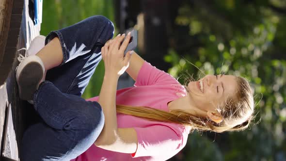 Vertical Screen Cheerful Woman Browsing Internet on Smartphone Outside