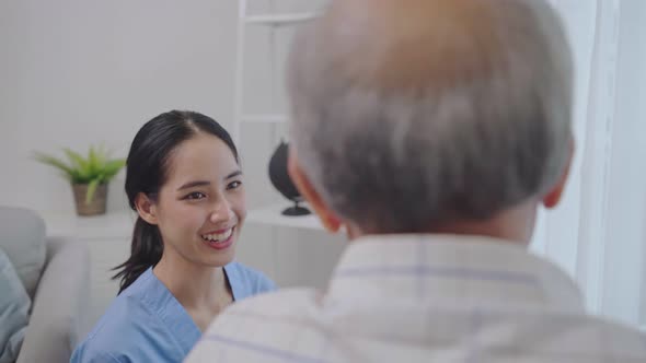 Asian nurse take care of senior man on wheelchair at the window