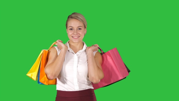 Young woman walking and hold shopping bags while doing