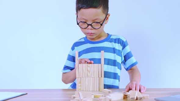 Asian boy playing with a wooden puzzle