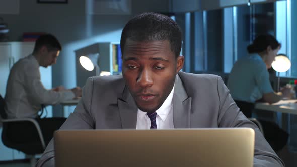 Closeup Portrait of AfricanAmerican Manager Work on Laptop and Get Surprised Results Late in Office