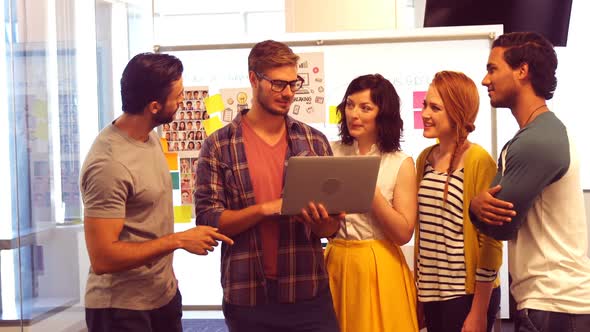 Business colleagues discussing over laptop