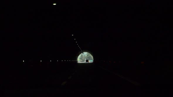 Driving pov through a tunnel on a highway freeway road.