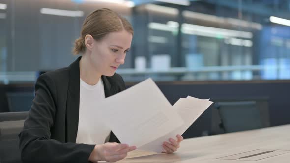 Businesswoman Reading Documents at Work