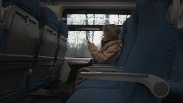 Woman In Train With Smartphone