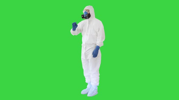 Scientist in Protective Suit and Respirator Pointing Futuristic Screen on a Green Screen, Chroma Key