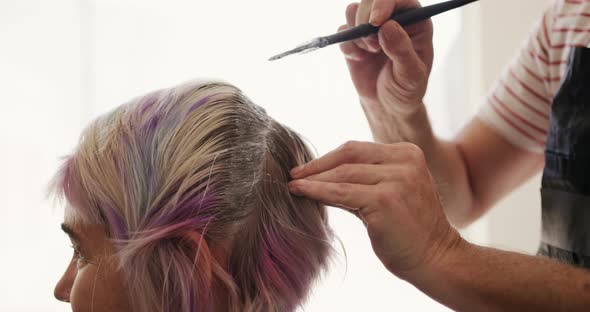 Side view woman having her hair styled by a hairdresser