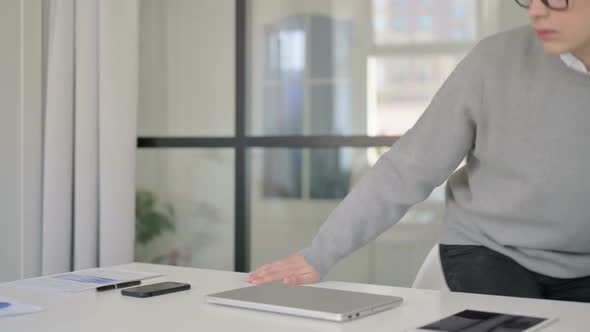 Young Man Coming and Opening Laptop Starting Work in Modern Office