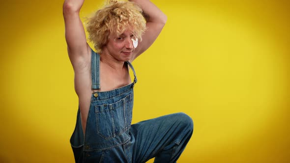 Tattooed Pierced Caucasian Androgynous Man Dancing in Slow Motion at Yellow Background