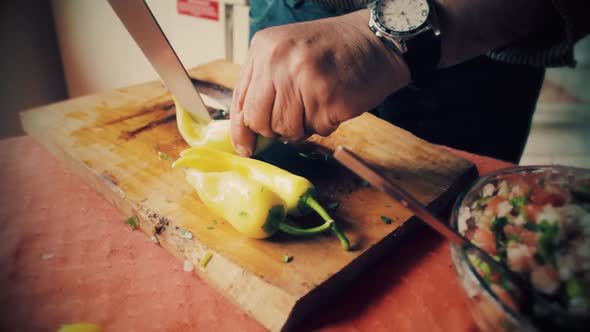 Cutting green pepper on a old style the cutting board to make a chilean organic salad