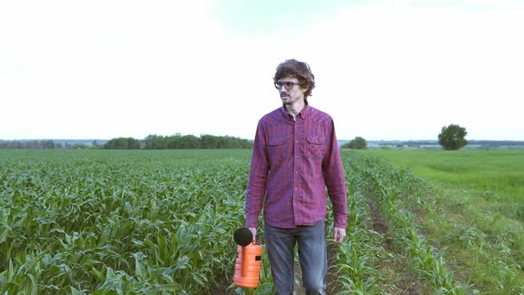 The farmer uses a watering can to water the plants and increase growth. Agricultural concepts