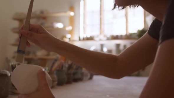 Young female potter working in her studio